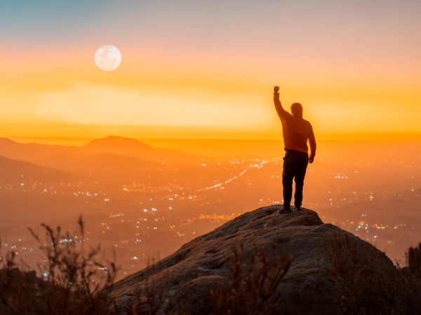 testimonial person standing on the top of the mountain